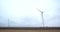 Renewable energy source, massive wind turbine is spinning in the field, 4k