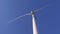 Renewable energy, white blades spin in air against blue heaven