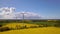 Renewable energy, wind energy with windmills. Wind turbines farm generating electricity on rapeseed fields - aerial view