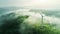 Renewable energy wind farm with windmill turbines in a green field on a foggy morning