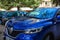 Reno car grille with chrome logo and front hood with reflections of spring sky and trees. Ble car parked on the street