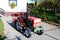 Renovated and repainted vintage retro old small compact utility tractor with new tyres parked on paved driveway of suburban house