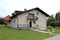 Renovated suburban family house with front balcony and stone tiles entrance surrounded with freshly cut green grass and small palm