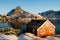 Renovated traditional red rorbu fishing hut on rocky coast near Reine on the Lofoten islands in Norway in winter with ocean and