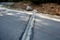 Renovation of asphalt road in the mountains. The ditches are filled with stones to slow down the water flowing out of the metal gr