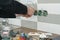 Renovation and construction in kitchen, close-up of electricians hand installing outlet on wall with ceramic tiles using