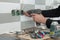 Renovation and construction in kitchen, close-up of electricians hand installing outlet on wall with ceramic tiles using