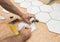 Renovation works - interior finishing worker tiler laying ceramic tiles on the floor