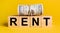 RENT with money on a yellow background. The concept of business, finance, credit, income, savings, investments, exchange, tax
