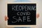 Reopening covid safe. Coronavirus concept. Boy hold inscription on the board