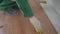 Repair, building and home concept - close up of male hands intalling wood flooring. The worker is laying the laminate.