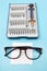 Repair of glasses. Glasses and a screwdriver on a blue background. Eyewear repair tools and accessories. Vertical