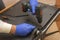 Repair of LCD TV in the service center. Engineer removes the back panel using an electric screwdriver. Selective focus, close-up