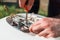 Repair and maintenance of the water heater. A man twists a screwdriver element of the water heater. Tool and fingers close up