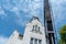 Repair of the old wooden roof of a beautiful historical building. The crane lifts the builders to a height on a special cradle or