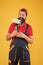 Repair paintng tool. cheerful bearded man worker with roller tool. hipster artist decorator yellow wall. erector