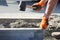 Repair of the sidewalk. Professional working masons in overalls lay curbs before laying stone paving slabs.