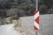 Repair sign on asphalt roadside. A wall made of stones on the side