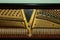 Repair of a stringed musical instrument. The interior of a piano with brass metal strings and a wooden mallet. Old