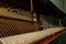 Repair of a stringed musical instrument. The interior of a piano with brass metal strings and a wooden mallet. Old