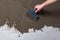 Repair the wall. Plastering the wall.Hand holding a spatula with construction mix.Applying putty or tile glue to the wall.Plaster