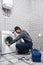 Repair washing mashine atantive. Working man plumber repairs a washing machine