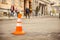 Repair work sign restricting traffic. White-orange plastic striped cone warning of danger. Tightening in traffic. Street of the