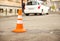 Repair work sign restricting traffic. White-orange plastic striped cone warning of danger. Tightening in traffic. Street of the