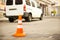 Repair work sign restricting traffic. White-orange plastic striped cone warning of danger. Tightening in traffic. Street of the