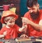 Repair and workshop concept. Father, parent with beard teaching little son to use tool screwdriver. Boy, child busy in