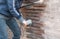 Repairing broken brick wall. Women cleaning grouts with a grinder.