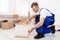 Repairman Assembling Furniture In Flat After Relocation, Wearing Blue Coverall