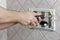 Repairman hands unscrewing a screw flush toilet box to fix bathroom closeup