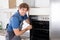 Repairman With Screwdriver Fixing Oven