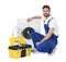 Repairman with toolbox near washing machine on white