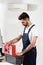 Repairman in uniform opening toolbox near