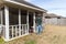 Repairman uses hammer to repair door on screened in back porch