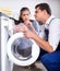 Repairman and woman near washing machine