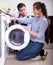 Repairman and woman near washing machine