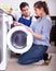 Repairman and woman near washing machine