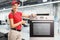 Repairwoman with a drill and oven at a factory looking at the cameraand smiling