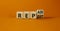 Repeat and repair symbol. Turned a wooden cube and changed the word repeat to repair. Beautiful orange table, orange background,