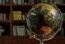 Replica globe on the background of bookshelves in library