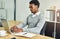 Replying to some emails. Cropped shot of a young businessman working on a laptop in a modern office.