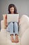 Replying to some emails. Full length shot of a young woman using her laptop while relaxing at home.