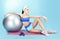 Repose. Sportswoman with Sport Equipment - a Fitness Ball and Dumbbells