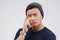 This requires careful thinking. Studio shot of a young man looking thoughtful against a gray background.