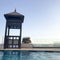 Rescue booth, tower, rescue post on the edge of the water of a luxurious infinity pool merging with the horizon against the backdr
