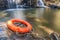 Rescue lifebuoy on rock with nature waterfall background.