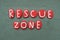 Rescue Zone, creative advice composed with red colored stone letter over green sand